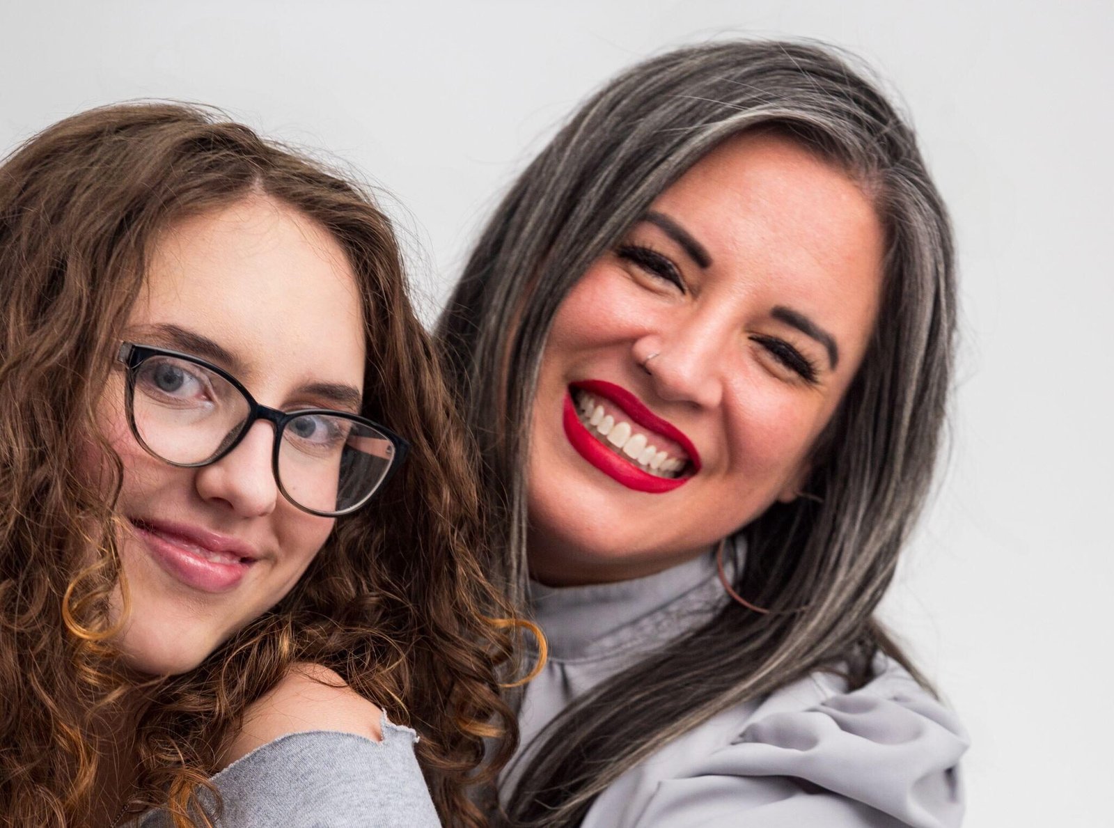 Mother and daughter hugging and smiling in a studio portrait for their holiday card