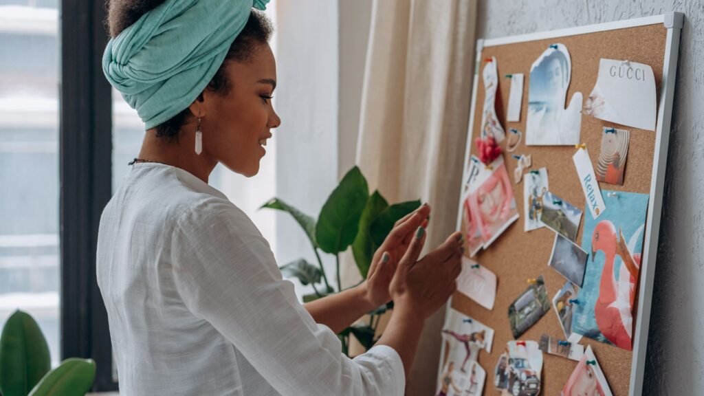 Woman arranging images and notes on her vision board